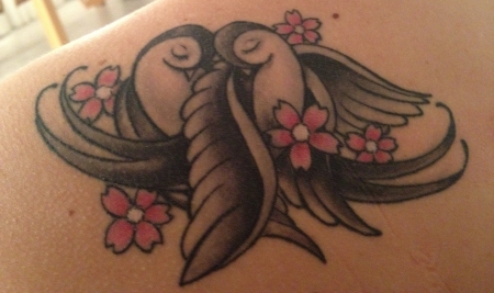 schwalben-Tattoo: zwei Schwalben mit Blumen