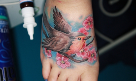 kirschblüten-Tattoo: realistisches Rotkehlchen mit Kirschblüten 